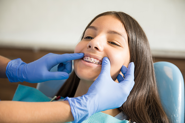 girl-with-braces-being-examined-by-dentist