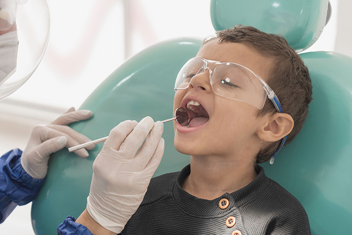 toddler-boy-getting-his-teeth-checked-by-a-dentist